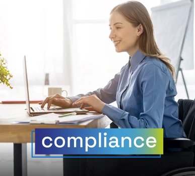 Woman in a wheelchair working on a laptop in a bright office space. Overlaid text: "compliance".