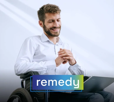 Young man in a wheelchair interacting with a laptop, smiling. Represents the use of digital remediation tools. Overlaid text: "remedy".
