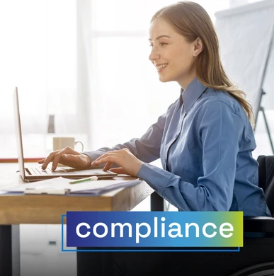 Woman in a wheelchair working on a laptop in a bright office space. Overlaid text: "compliance".